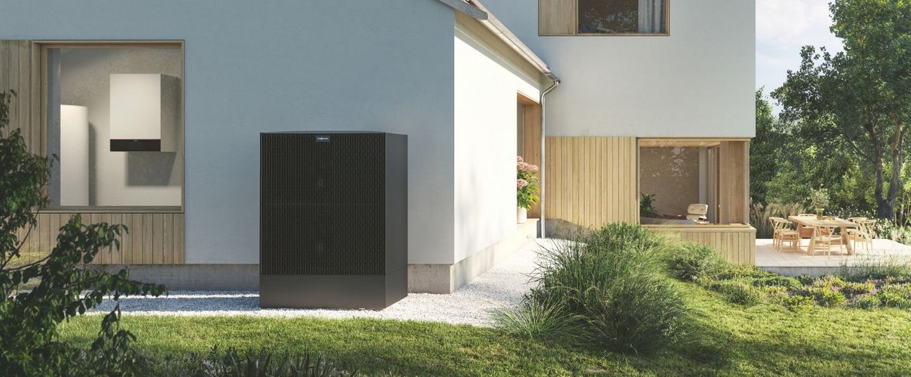 Das Einstiegsbild zeigt eine schwarze Wärmepumpe vorm Haus.
