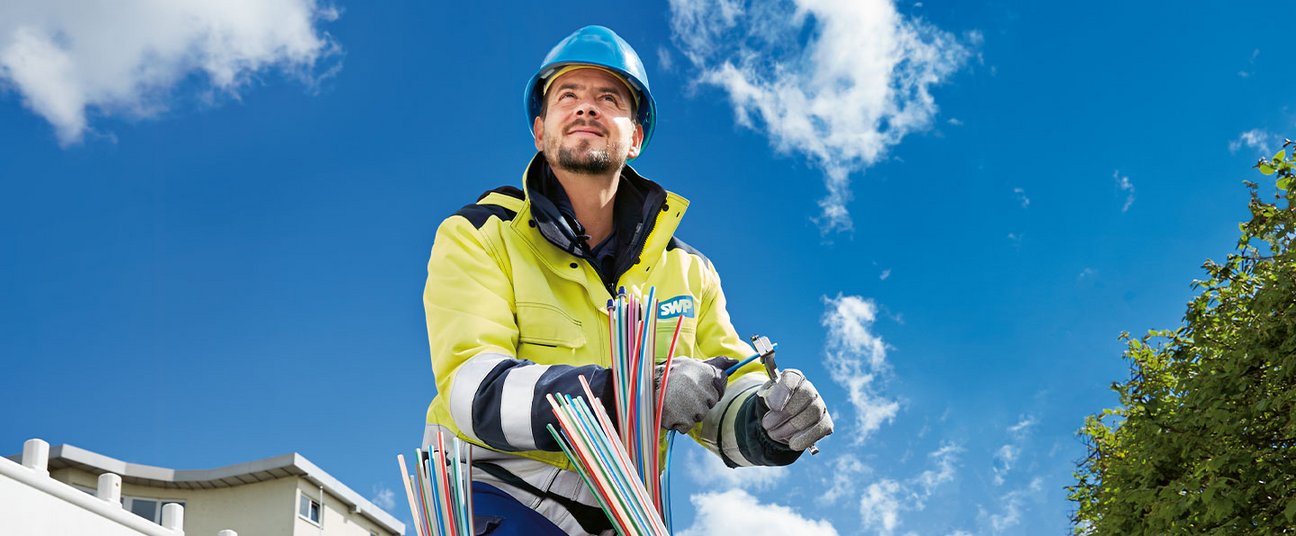 Das Einstiegsbild zeigt einen Handwerker, der einen Glasfaseranschluss verlegt.