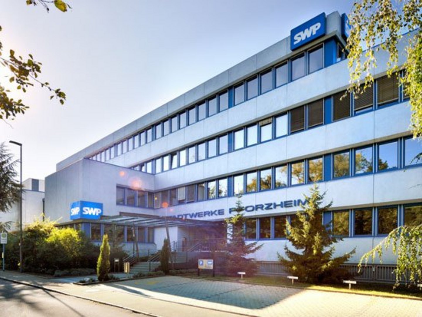 Hauptgebäude der Stadtwerke Pforzheim bei Tageslicht, mit SWP-Logos an der Fassade und modernem Eingangsbereich.