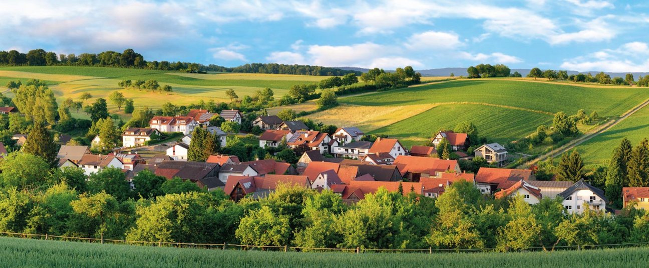 Das Einstiegsbild zeigt eine schöne Gemeinde im Grünen