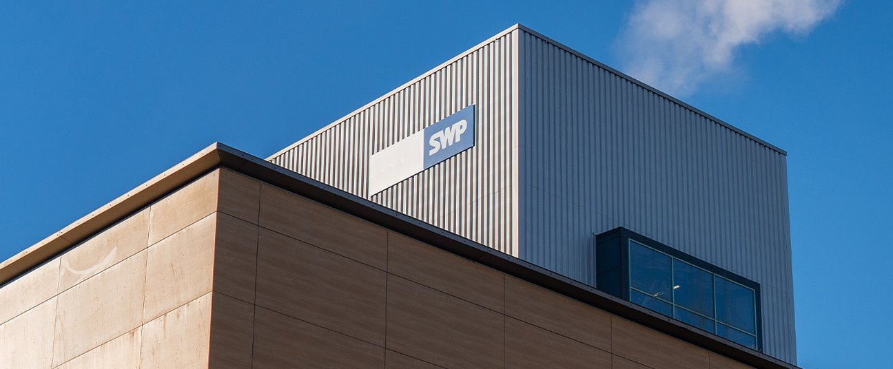Gebäude mit SWP-Logo vor blauem Himmel.