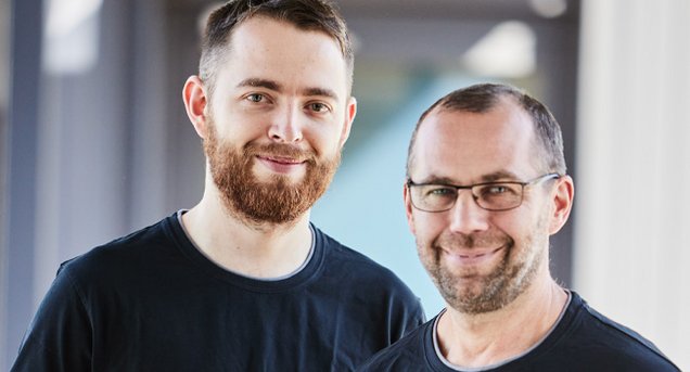 Die beiden Ausbilder Dominik Holm und Josef Janson lächeln in die Kamera.