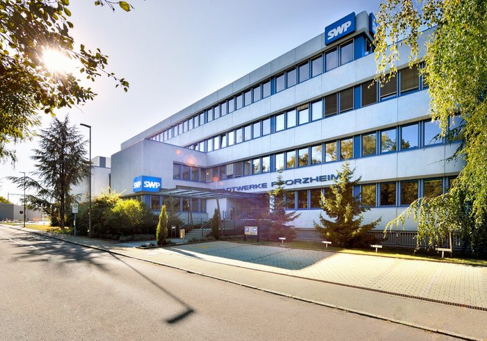 Die Front des Verwaltungsgebäudes der Stadtwerke, umgeben von Natur.