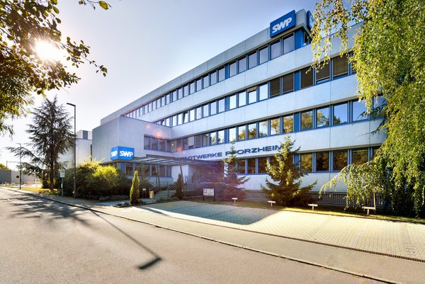 Die Front des Verwaltungsgebäudes der Stadtwerke, umgeben von Natur.