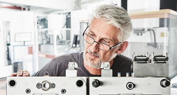 Das Bild zeigt einen Unternehmer, der eine Qualitätskontrolle durchführt.