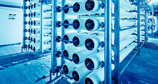 Bild unserer Ultrafiltrationsanlage, man sieht die verschiedenen Filterrohre, die blau angeleuchtet werden.