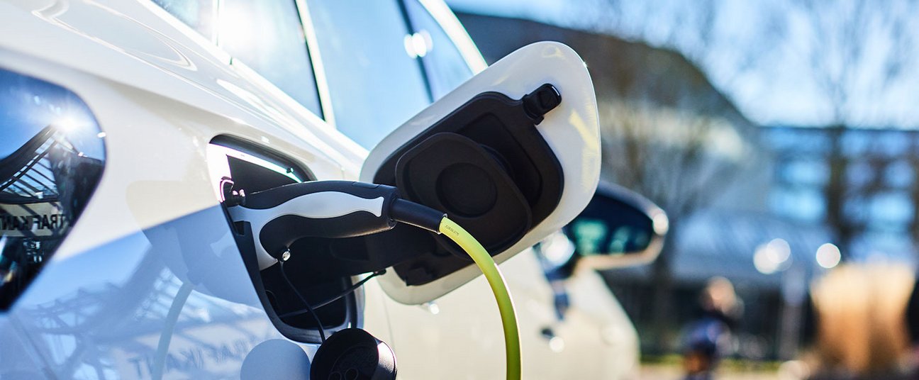 Das Einstiegsbild zeigt ein Elektroauto das an einer Ladesäule hängt.