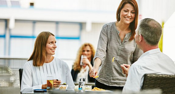 Das Bild zeigt die Kollegen in der Kantine gemeinsam Essen