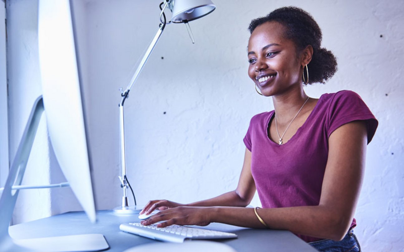 Das Bild zeigt eine junge Frau am Desktop-PC.