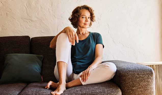 Frau sitzt entspannt auf einem Sofa